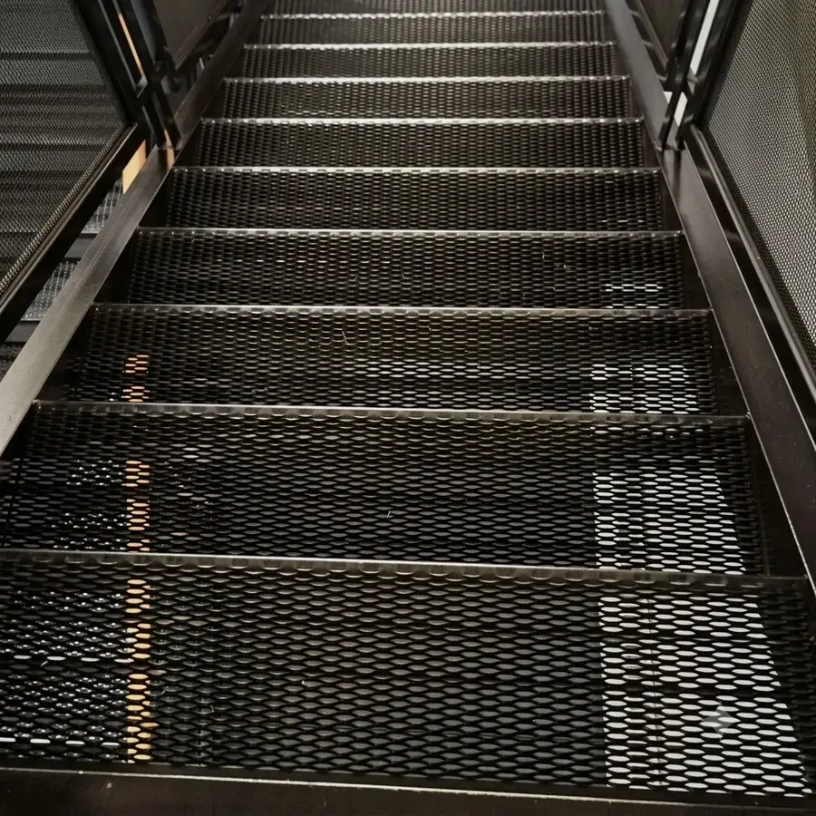 Black coated expanded metal stair treads installed indoors
