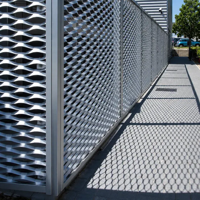 Expanded metal perimeter screen beside a commercial walkway