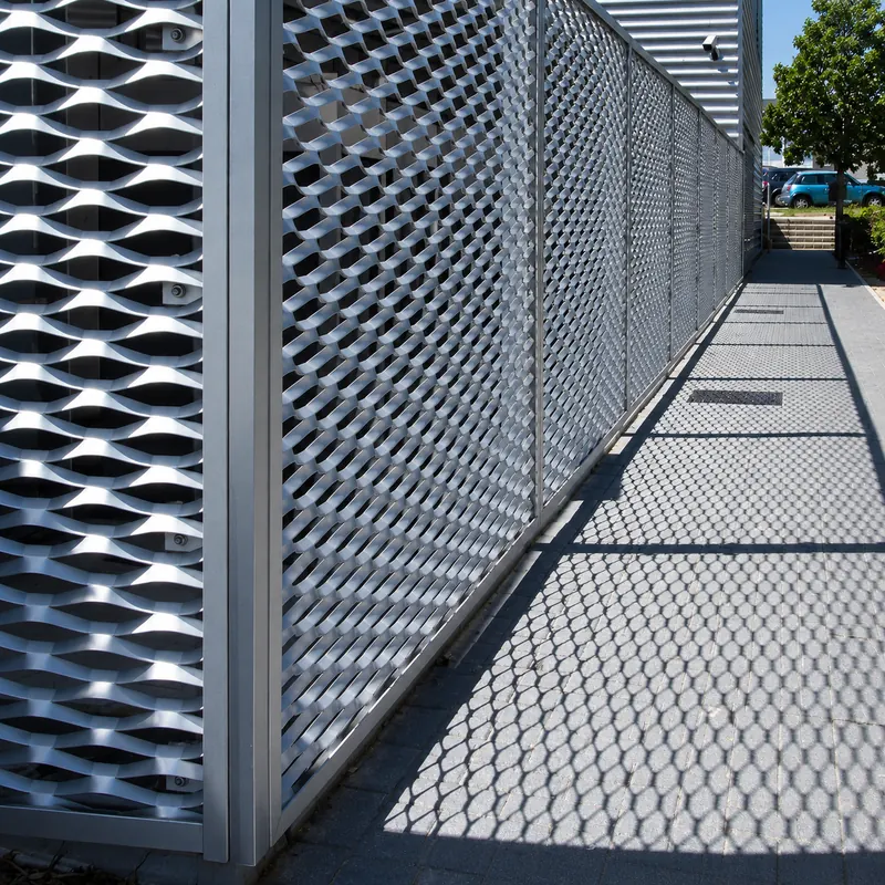 Expanded metal perimeter screen beside a commercial walkway