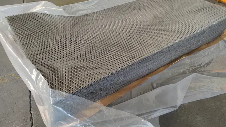 Stacked expanded metal sheets with protective film prepared for shipment
