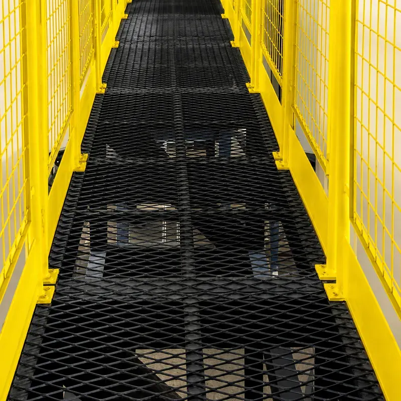 Black powder-coated expanded metal catwalk with yellow guardrails