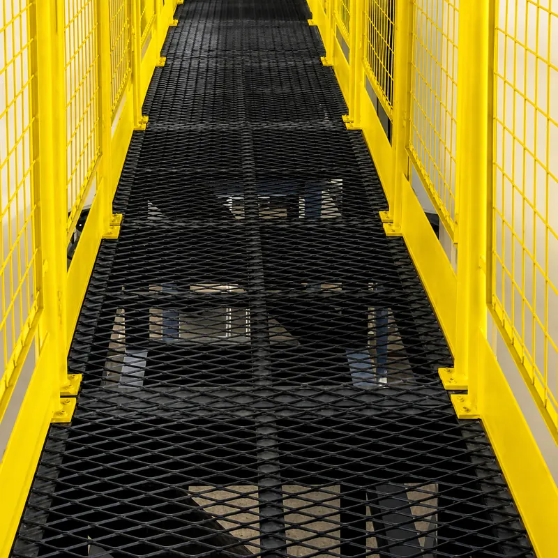 Black powder-coated expanded metal catwalk with yellow guardrails