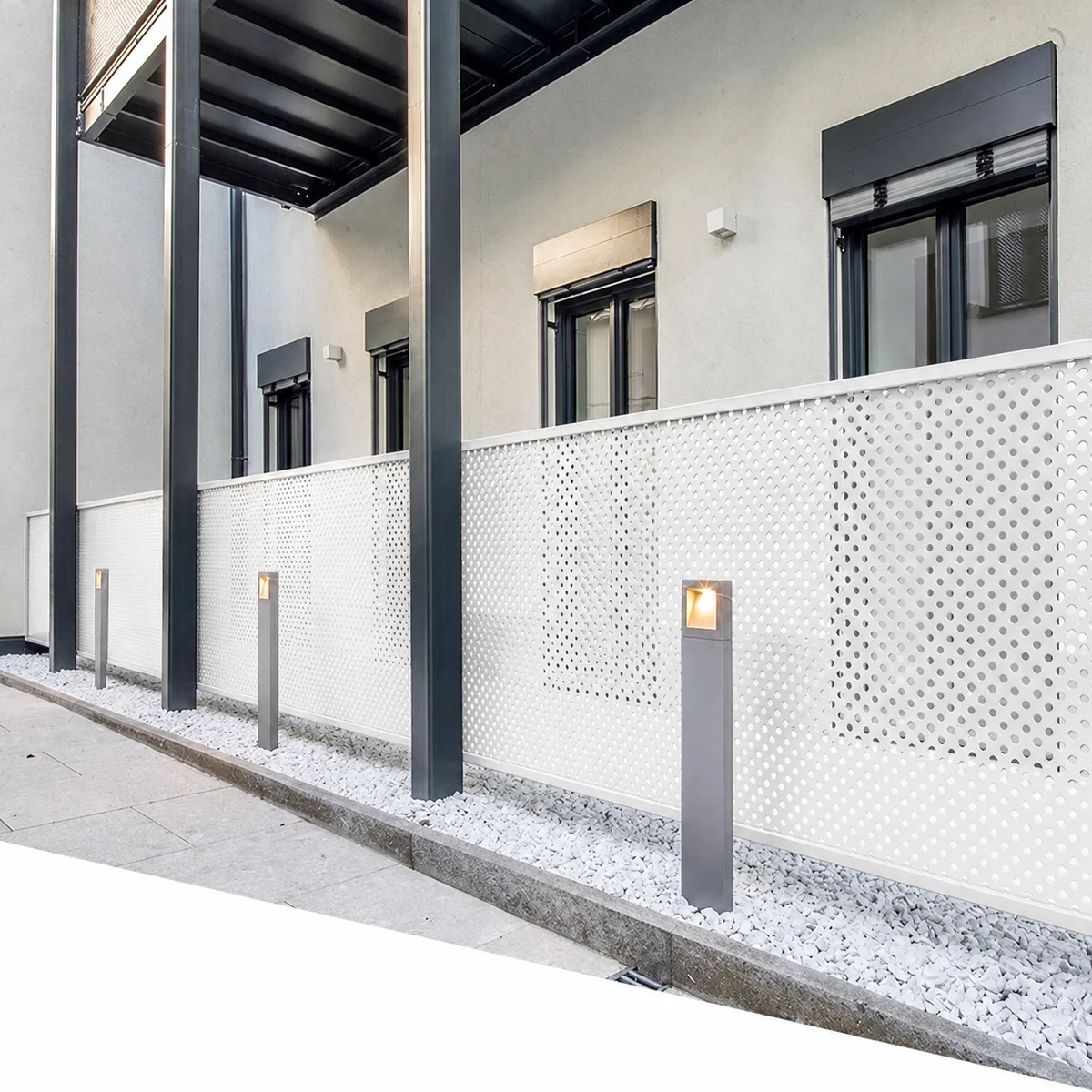 White perforated metal balcony screen panels on a modern building