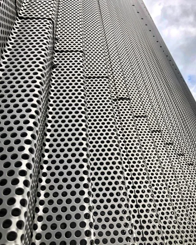 Close-up of white perforated metal wall panels with round holes