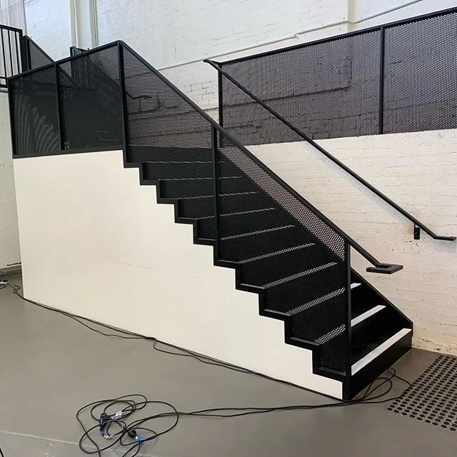 Black perforated metal stair railing and guard panels