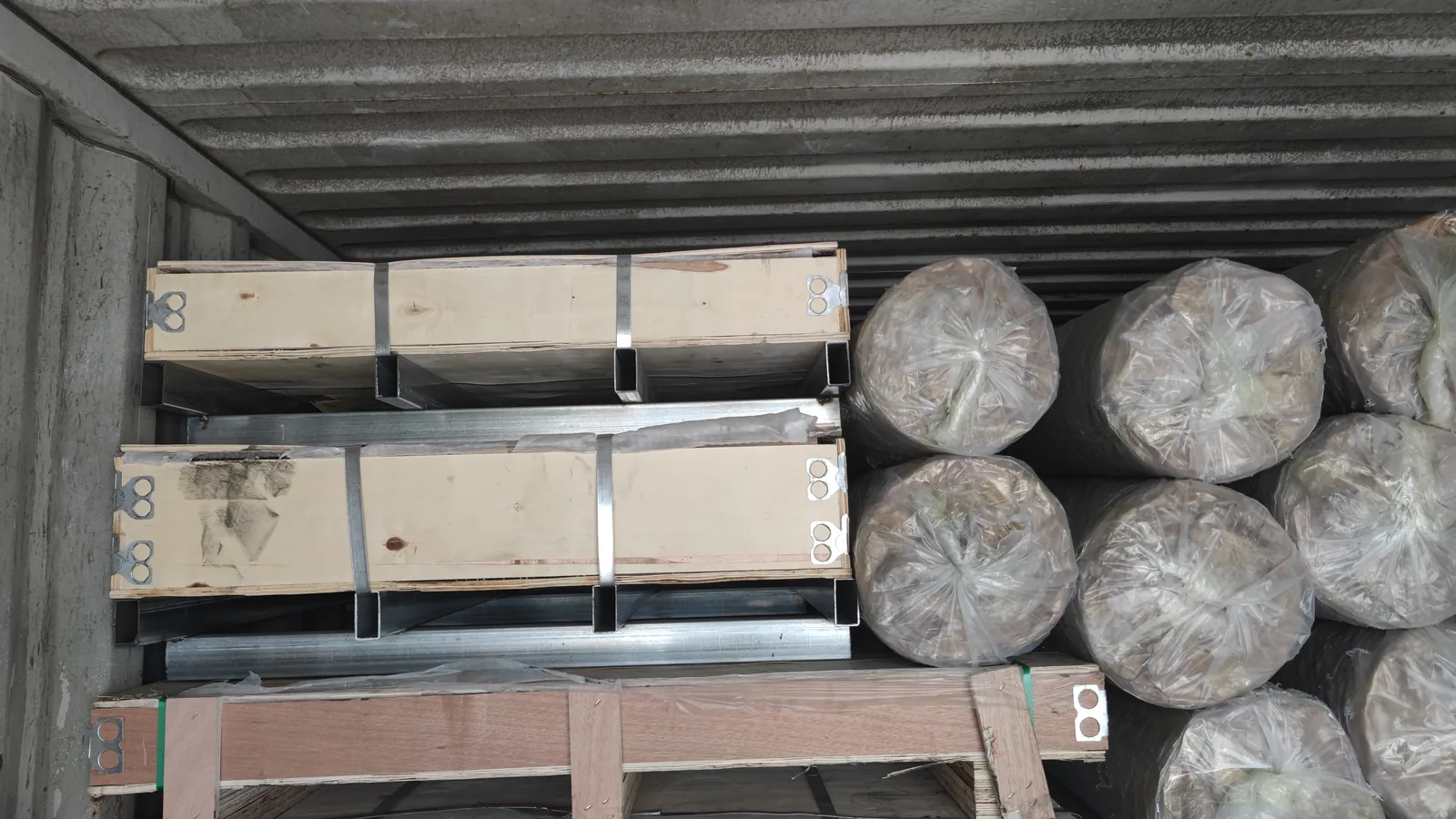 Wooden cases and wrapped expanded metal rolls loaded in a container