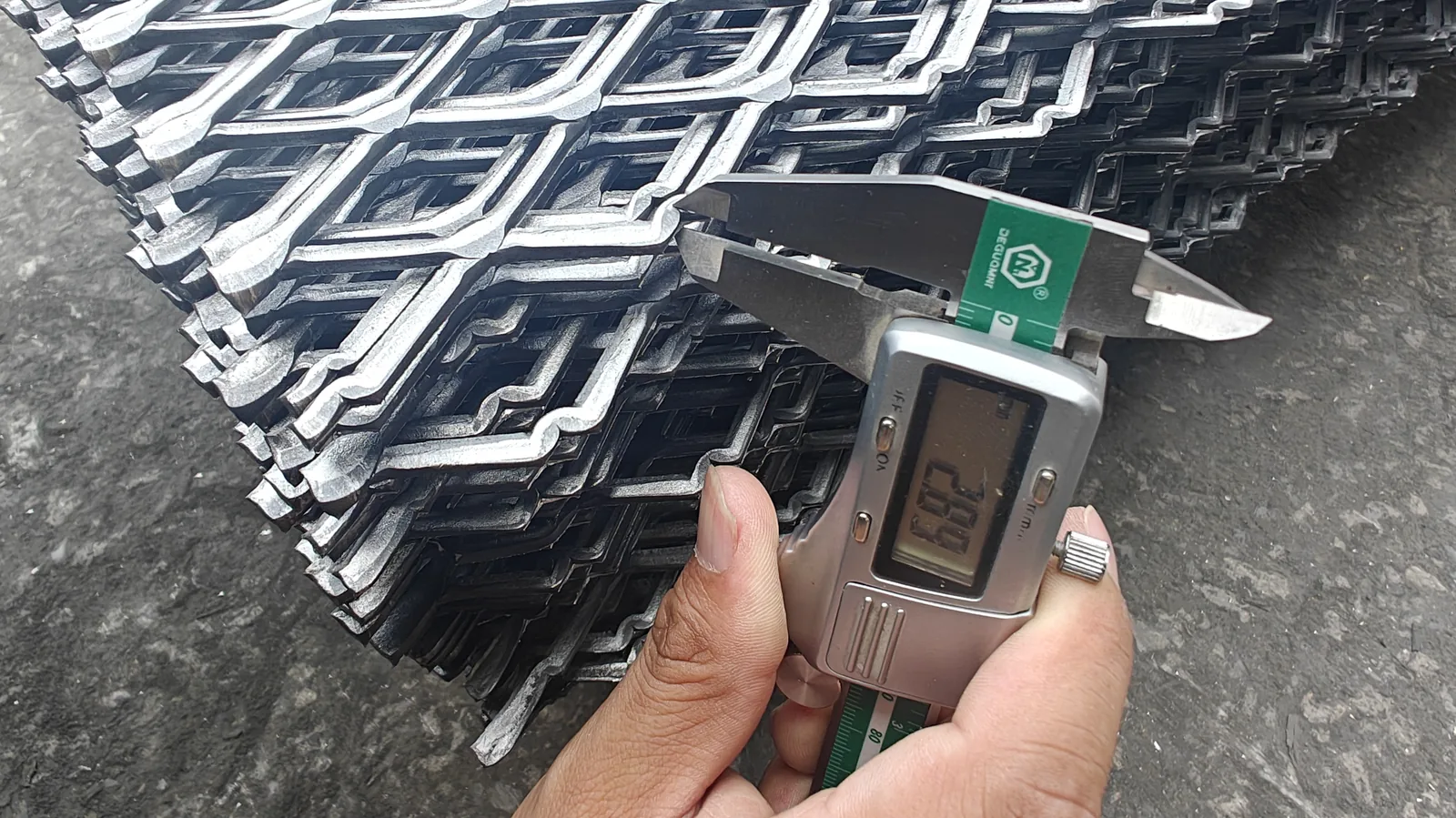 Digital caliper checking expanded metal strand thickness