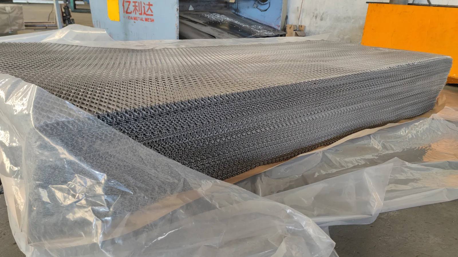 Expanded metal sheets protected with plastic film for packaging