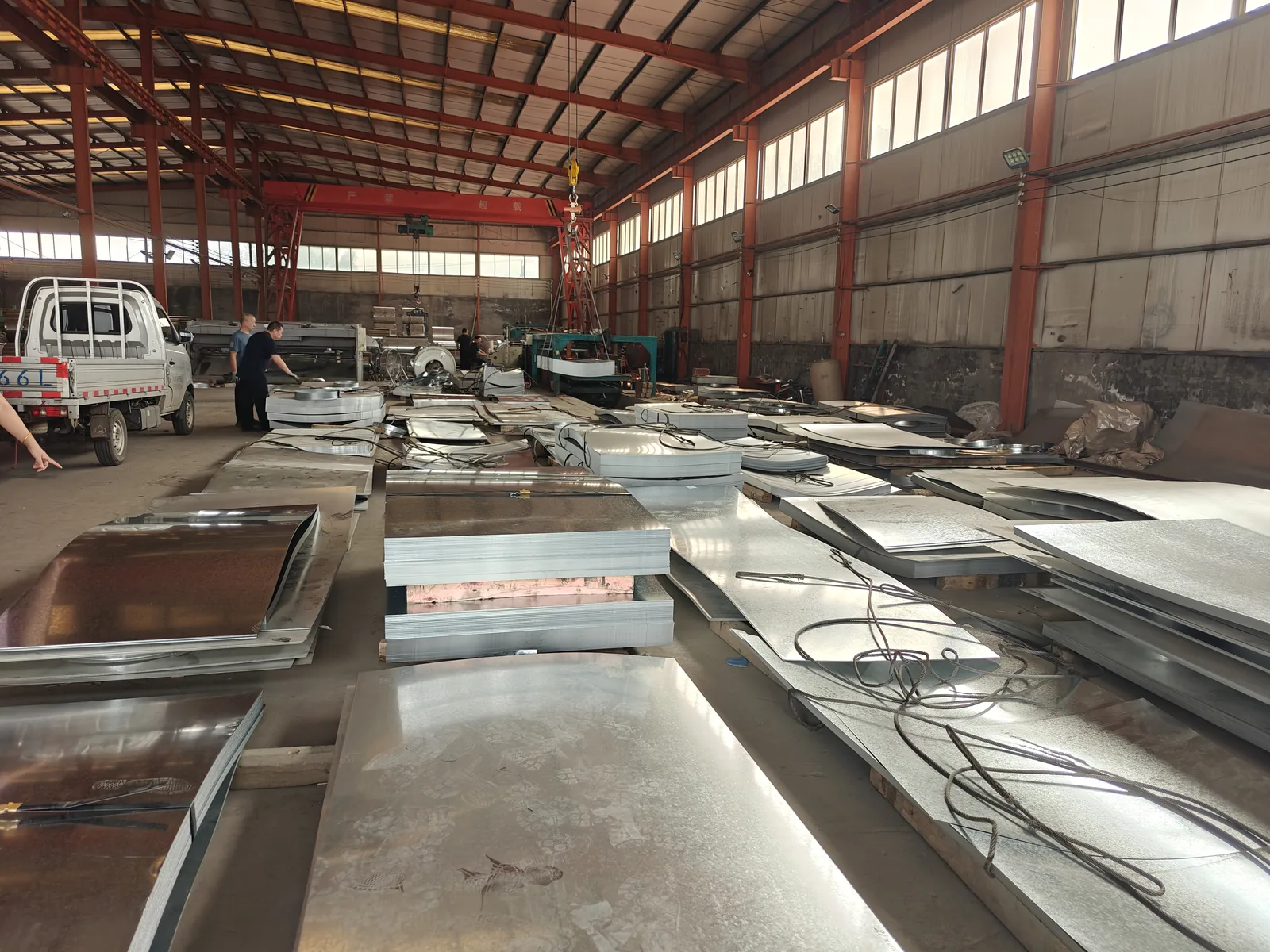 Stacked metal sheets and coils in a factory raw material area