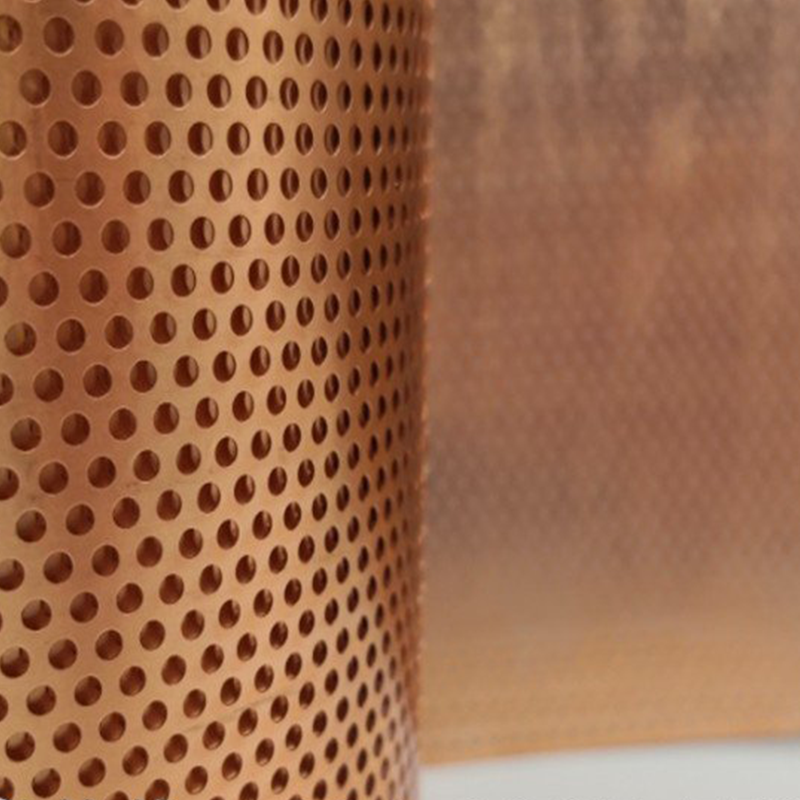 Copper perforated metal sheet close-up with staggered round holes