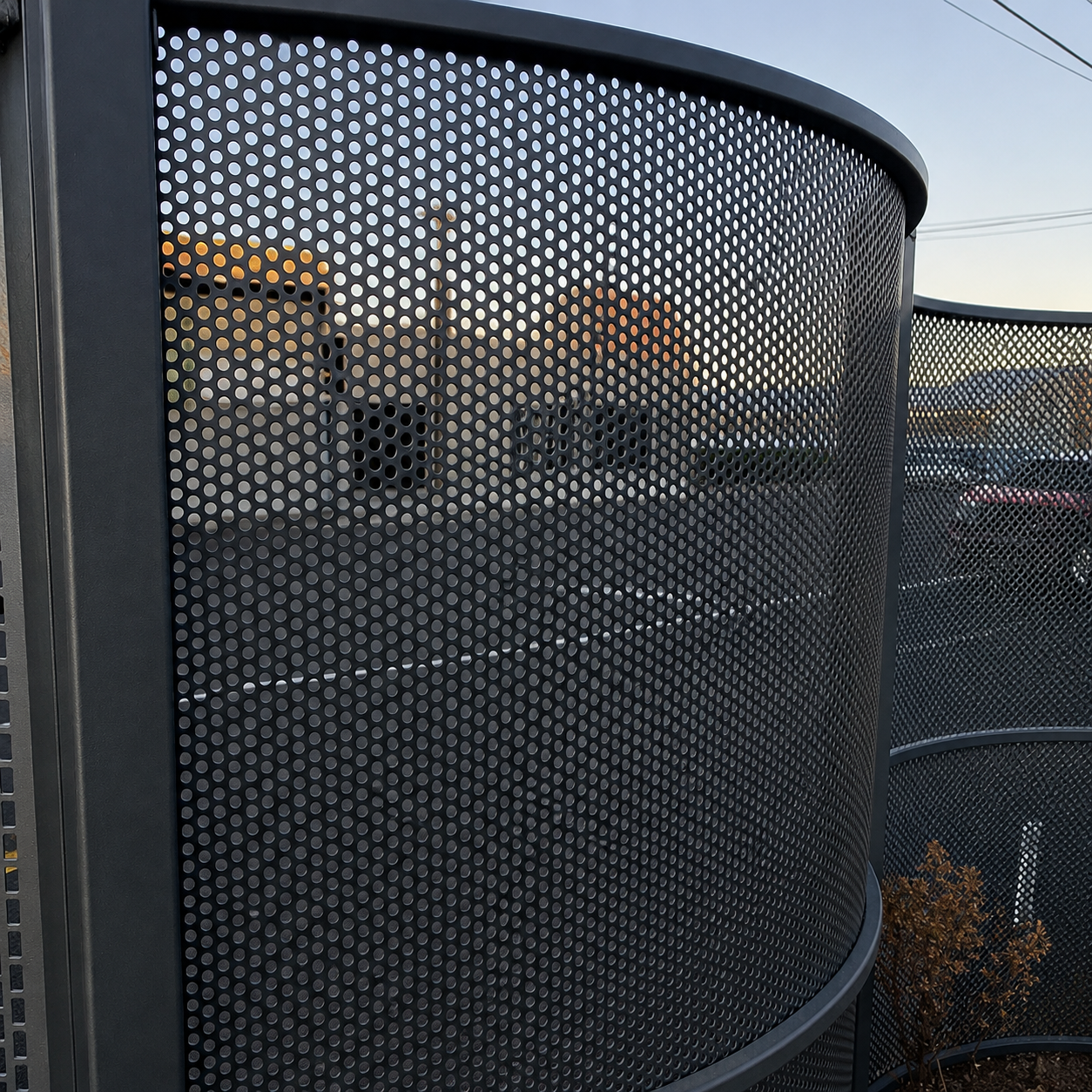 Curved perforated metal privacy screen panels with round holes