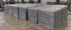 Stacked stainless steel welded wire mesh panels in a factory ready for bulk shipment