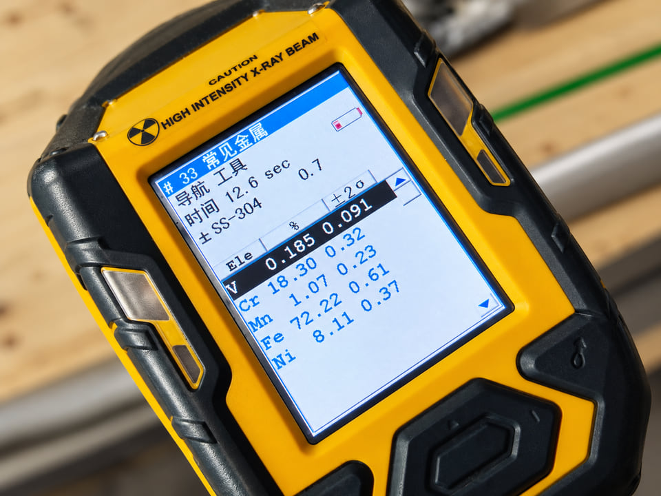 Handheld XRF analyzer screen identifying a stainless steel wire mesh sample as SS304 with chromium and nickel readings visible