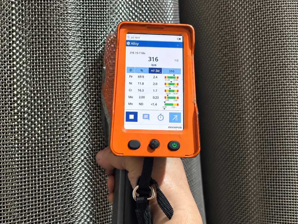 Handheld XRF analyzer identifying a stainless steel mesh sample as SS316